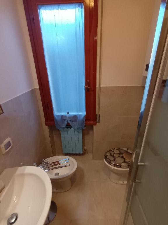 a bathroom with a toilet and a sink and a shower at Caletta Beach in Castiglioncello