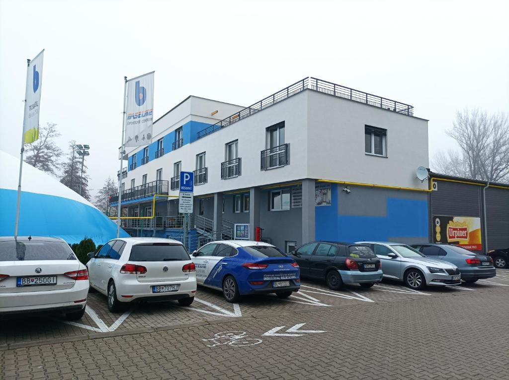 um parque de estacionamento com carros estacionados em frente a um edifício em BASELINE športový areál & penzión em Banská Bystrica