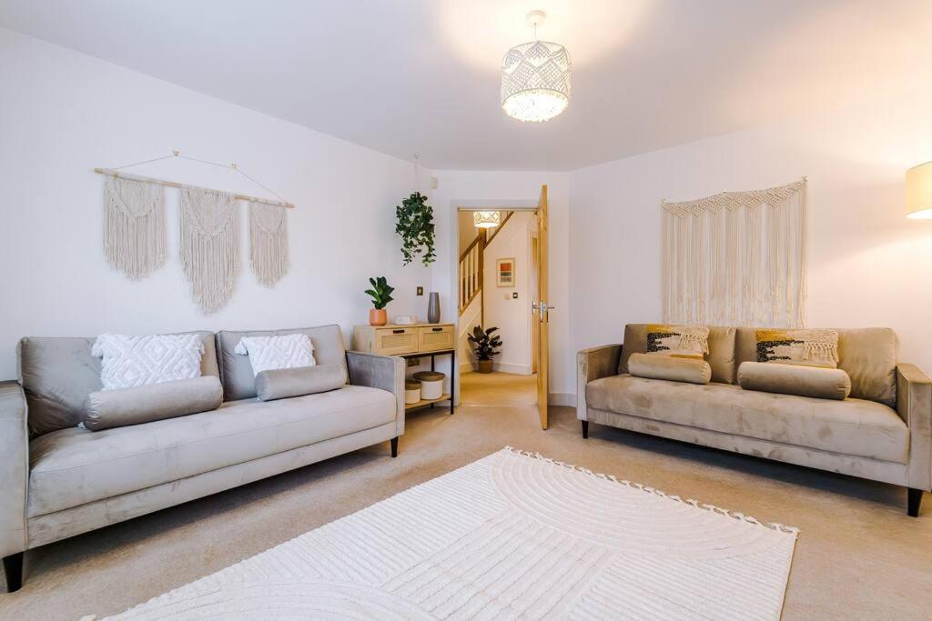 ein Wohnzimmer mit 2 Sofas und einem Tisch in der Unterkunft Luxurious Cosy 4BR Home Cheshire in Saughall