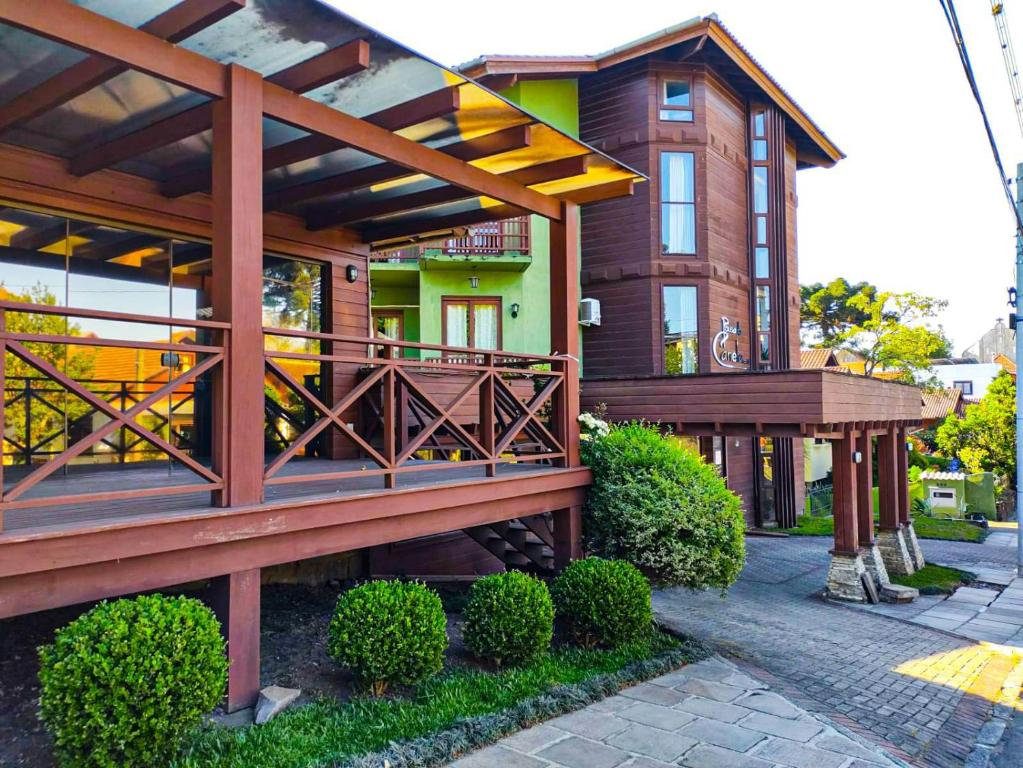 een huis met een houten terras en een balkon bij Pousada Suíça in Canela