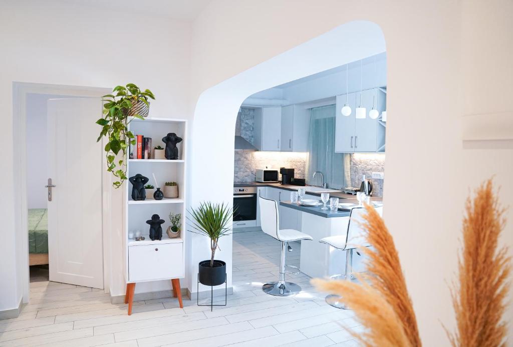una cocina con armarios blancos y una mesa con una maceta. en SunStone Apartment, en Fira