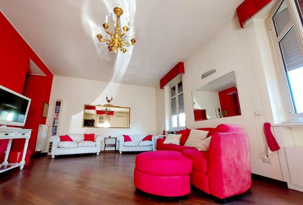 una sala de estar con muebles rojos y blancos y una lámpara de araña. en Appartamento 3 Cuori en Terni