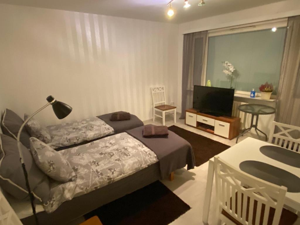 Schlafzimmer mit einem Bett und einem Flachbild-TV in der Unterkunft Koskentien yksiö in Jämsä