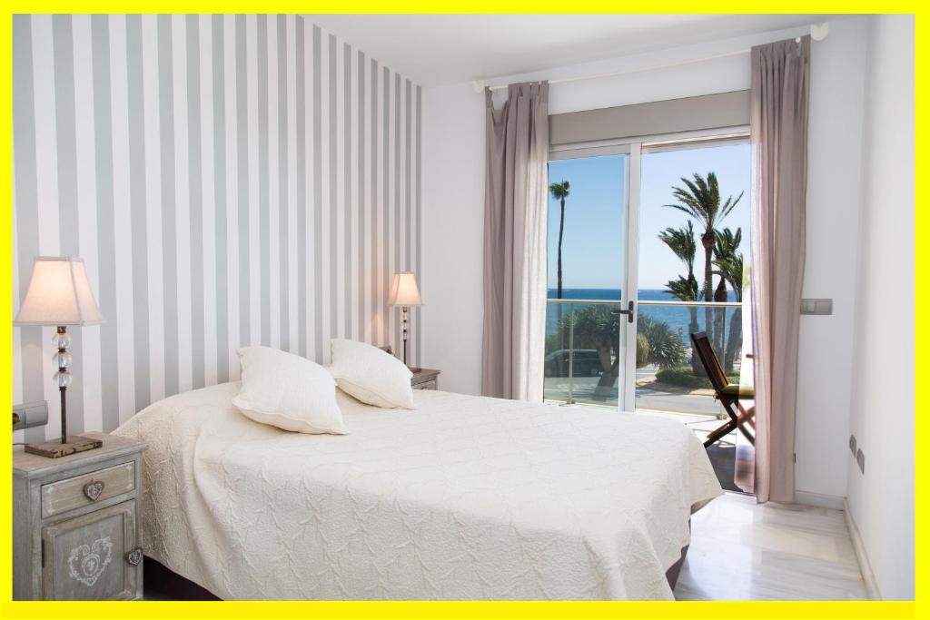 a bedroom with a bed with a view of the ocean at Victoria Port Javea in Aduanas