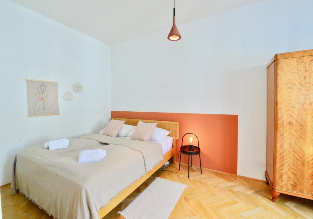 1 dormitorio con 2 camas y pared de color naranja en Beautiful Flat Next to Karlskirche en Viena
