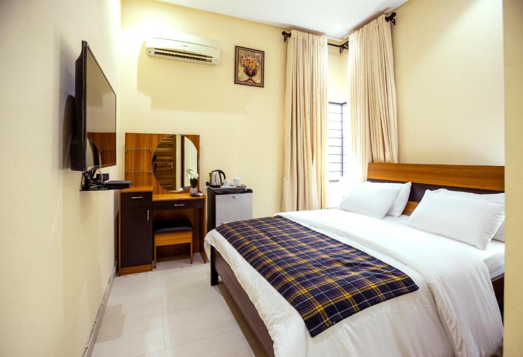 a hotel room with a bed and a desk at Rushmore - Standard Room in Lagos