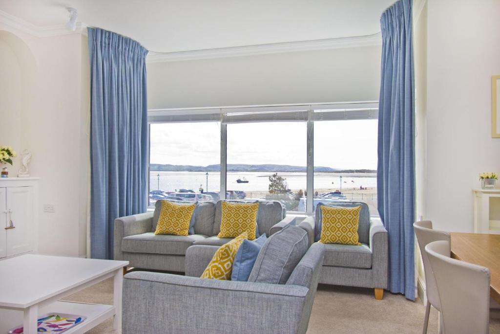 a living room with a couch and a large window at Beautiful Aberdovey Seafront Apartment 2 in Aberdyfi