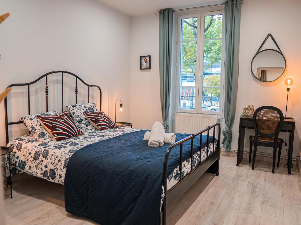 um quarto com uma cama com um edredão azul em L'annexe Clermont Ferrand em Clermont-Ferrand