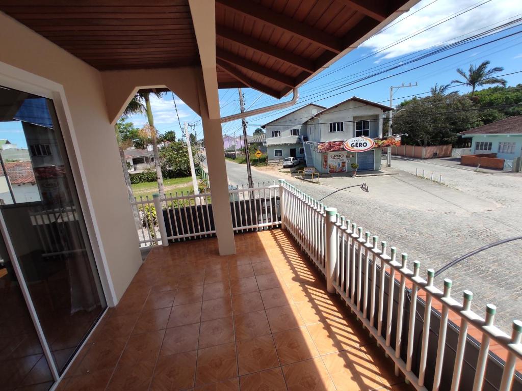 a balcony of a house with a fence and a street at Casa aconchegante a 4km-5min da Guarda do Embaú in Guarda do Embaú