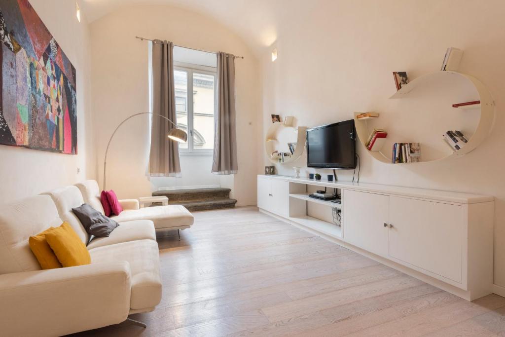 a living room with a couch and a tv at Le Grazie Luxury Apartment in Florence