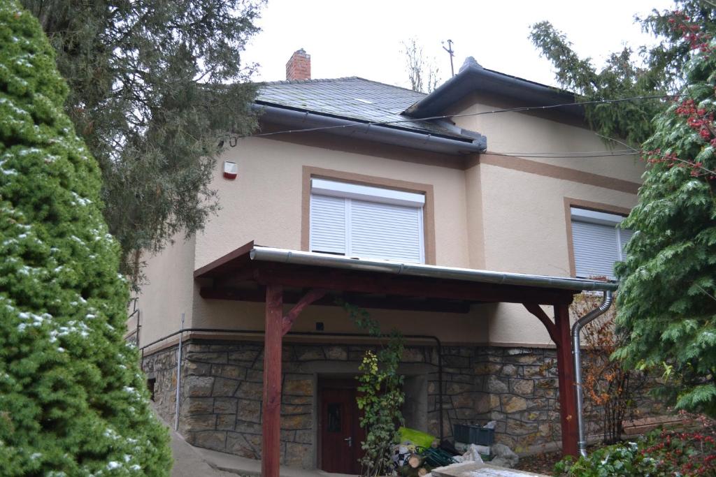 una casa con fachada de piedra y porche en Vár-lak Vendégház, en Szendrő