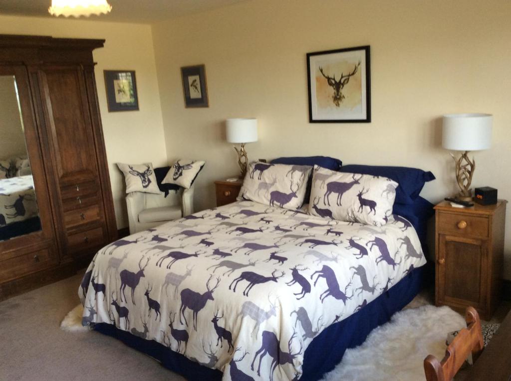 a bedroom with a bed with a blue and white comforter at NIGHTINGALE B&B in Pershore