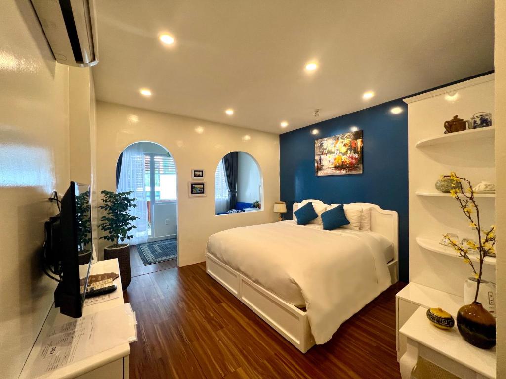 ein Schlafzimmer mit einem großen Bett mit einer blauen Wand in der Unterkunft Chez Mimosa Corner - New address 90 Đề Thám in Ho-Chi-Minh-Stadt