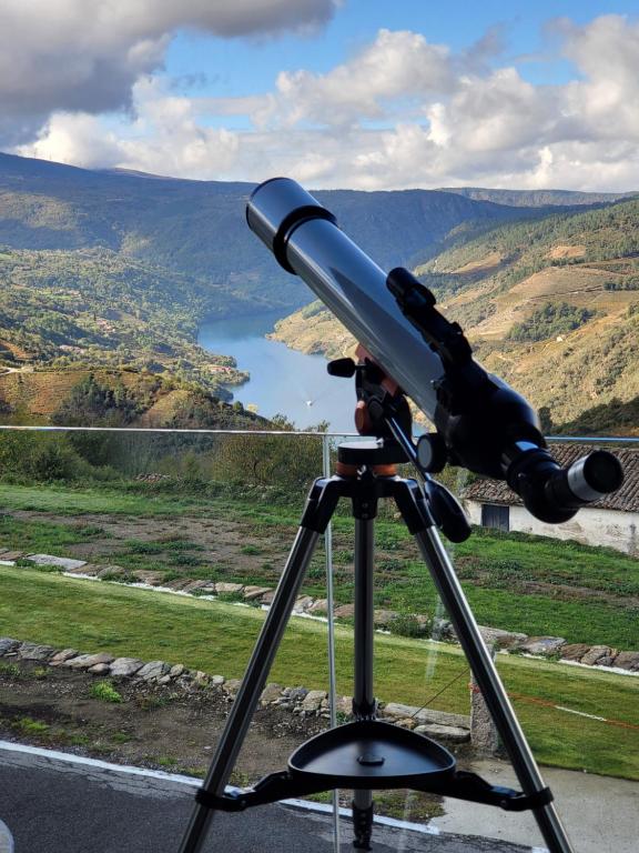 a telescope on a tripod looking out at a lake at Miradores do Sil Hotel Apartamento in Cristosende