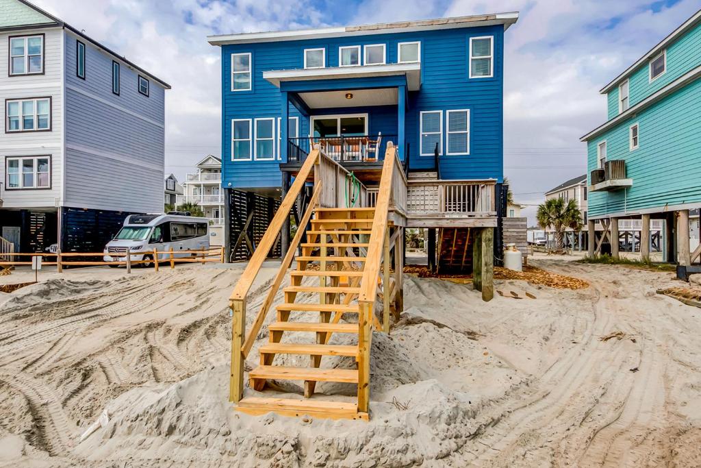 una casa azul con una escalera en la arena en Blue Wave en Myrtle Beach