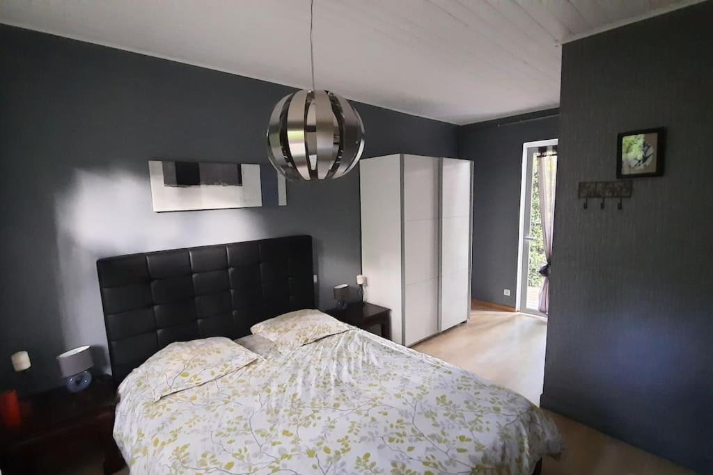 a bedroom with a bed and a black wall at La Cabane aux Acacias~vacances nature et au calme in Mézos