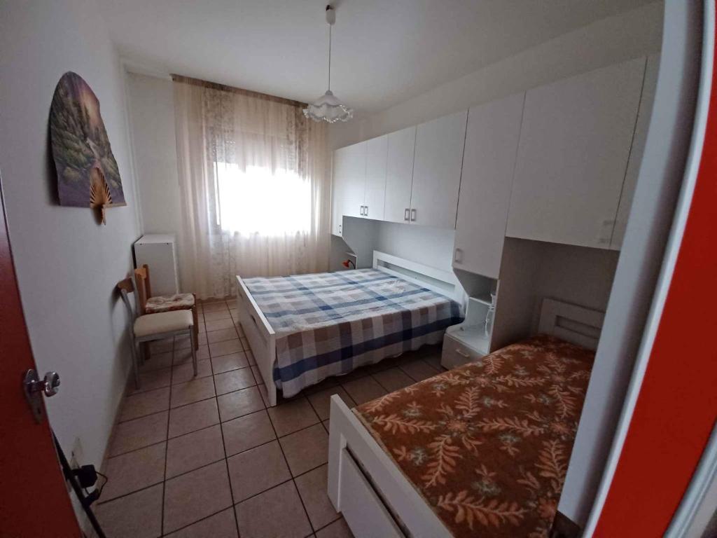 een kleine kamer met 2 bedden en een raam bij Apartment in Rosolina Mare 24985 in Rosolina Mare