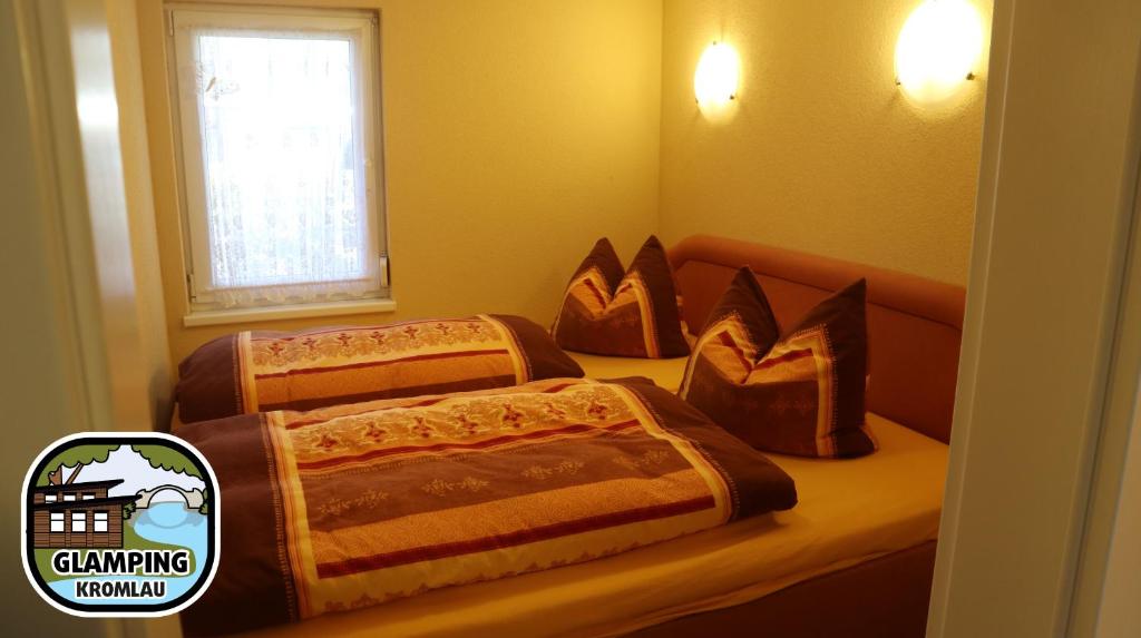 2 camas en un dormitorio con ventana en Glamping Kromlau en Gablenz