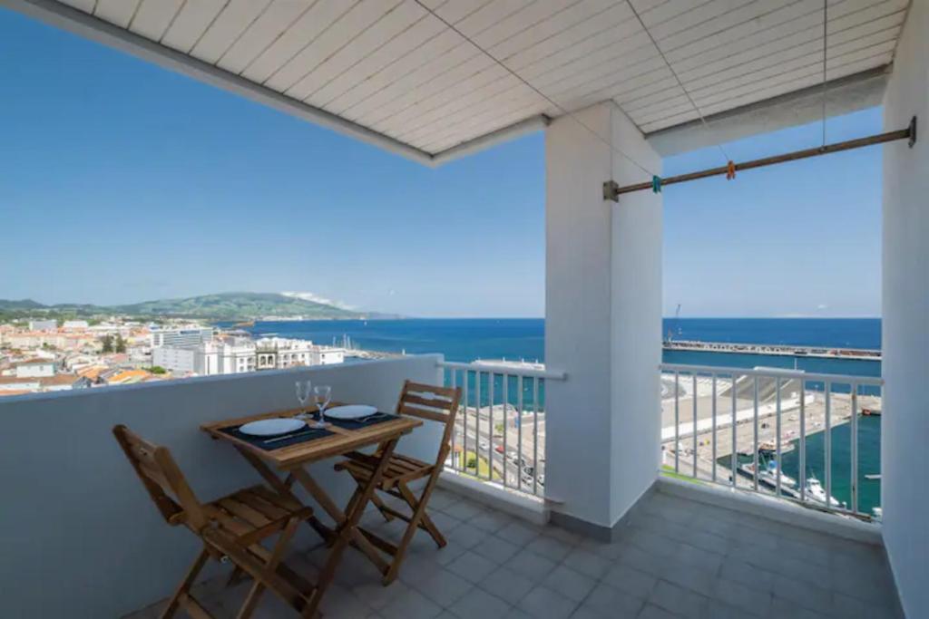 a balcony with a table and chairs and the ocean at Paradise Stunning Views - Best Location on Island in Ponta Delgada