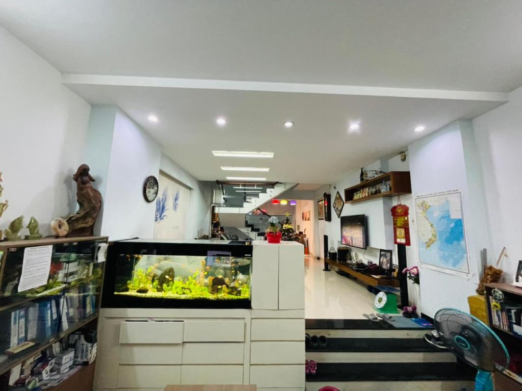 Helen's homestay في مدينة هوشي منه: غرفة مع حوض سمك كبير في الوسط