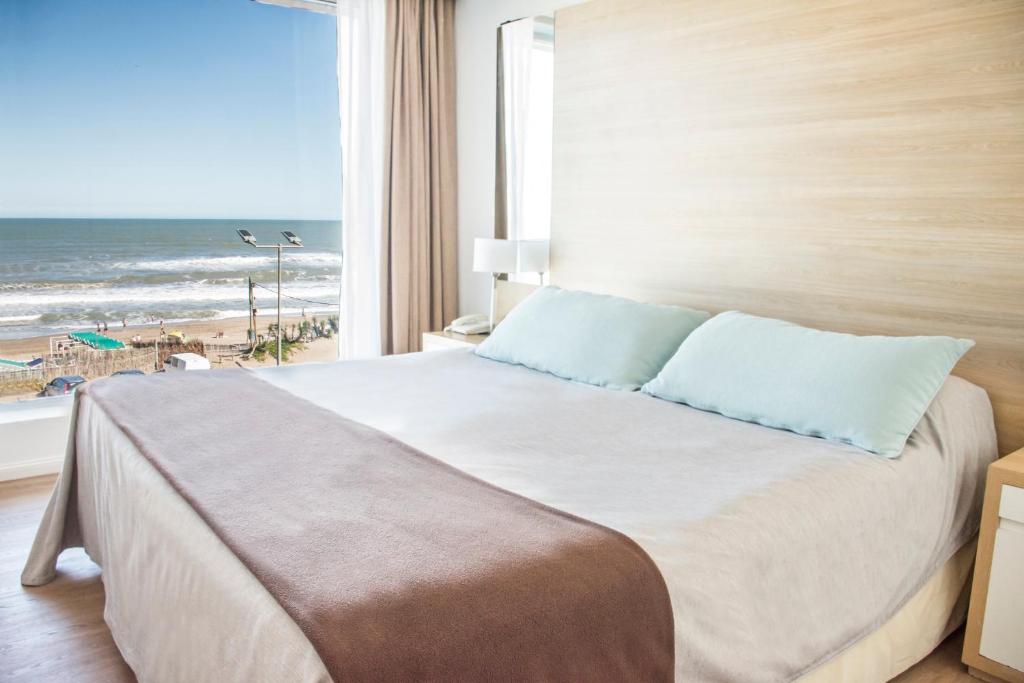 1 dormitorio con 1 cama y vistas a la playa en Pinamar Beach Resort en Pinamar