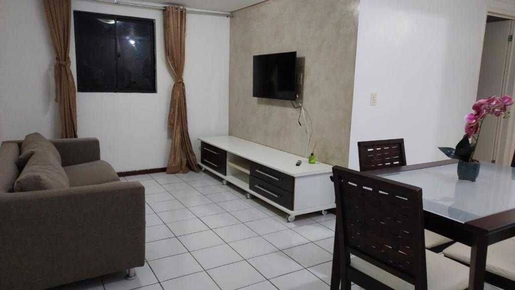 a living room with a couch and a table at Conforto e tranquilidade, 2 quartos, próximo à praia in Maceió