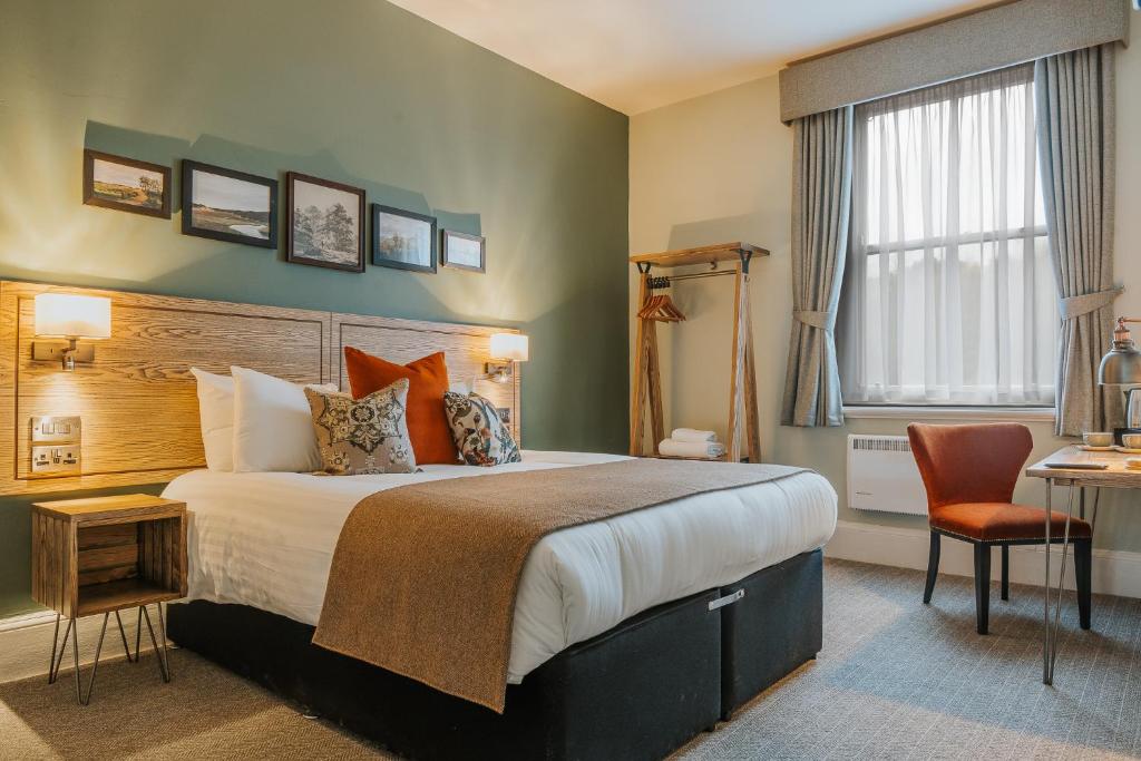 a hotel room with a bed and a chair at Grouse & Claret, Matlock by Marston's Inns in Matlock