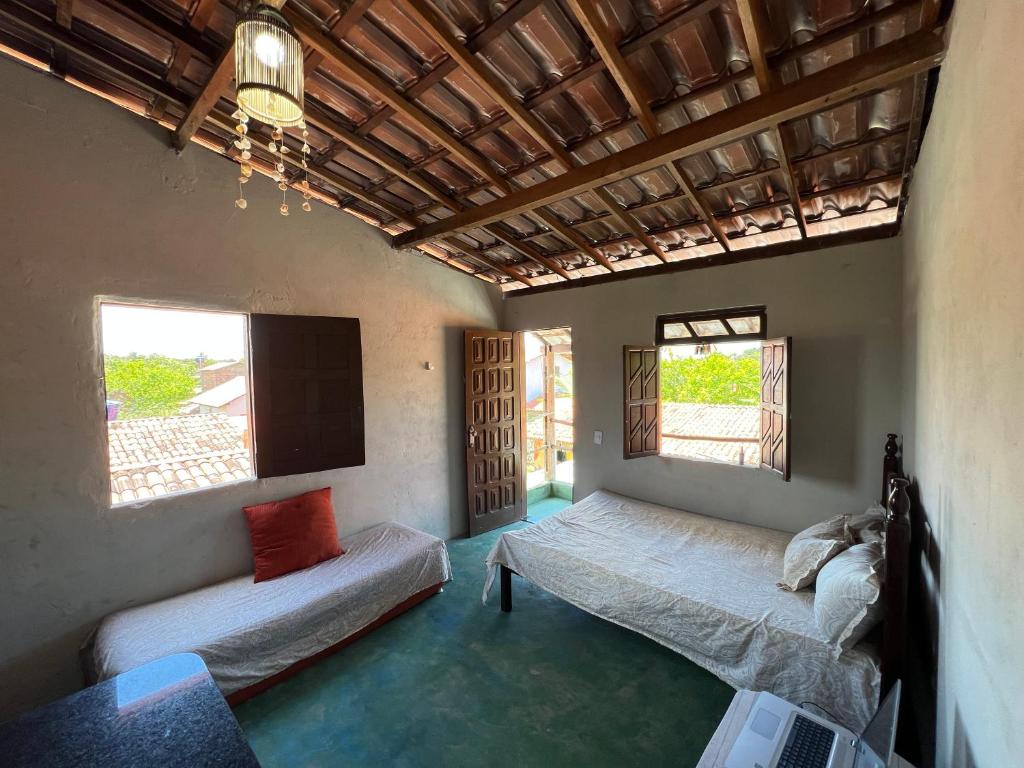 um quarto com 2 camas e 2 janelas em Pousada Maré Alta em Boipeba na Ilha de Boipeba