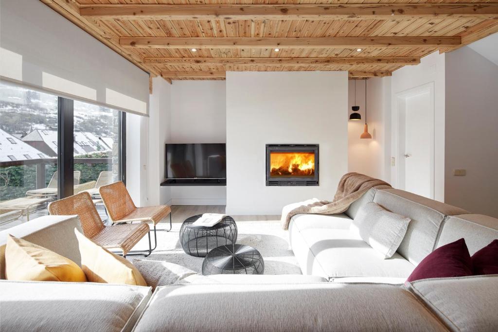 a living room with white furniture and a fireplace at Inuit by FeelFree Rentals in Vielha