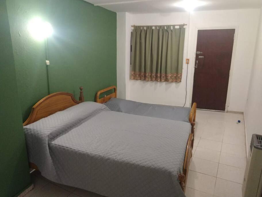 1 dormitorio con 2 camas y pared verde en Alojamiento del Valle en Godoy Cruz
