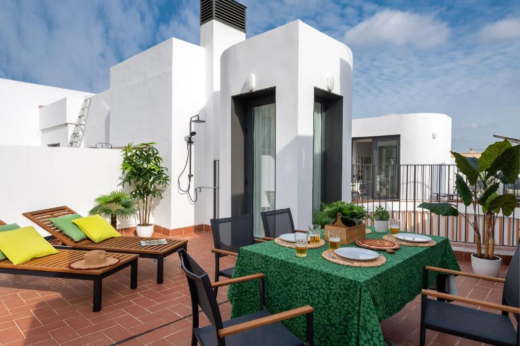 un patio con mesas y sillas y una casa blanca en Avanti Clavel, la terraza te conquistará, en Sevilla