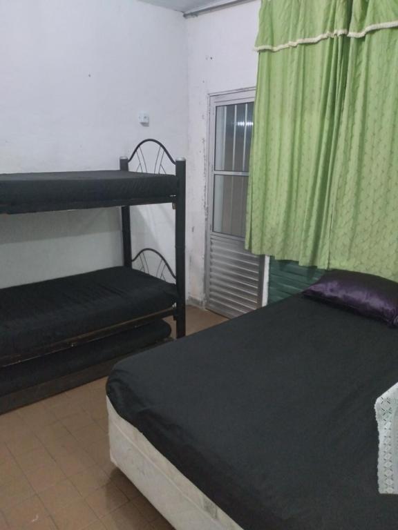 a bedroom with two bunk beds and a window at Recanto in Mongaguá