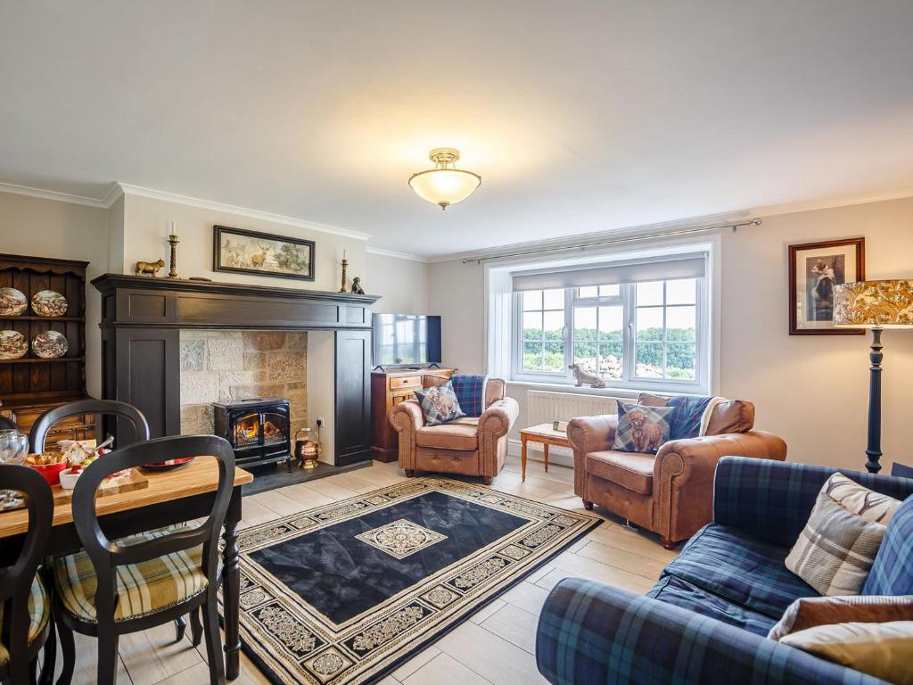 a living room filled with furniture and a fireplace at Farmside Cottage-uk35018 in Chatton