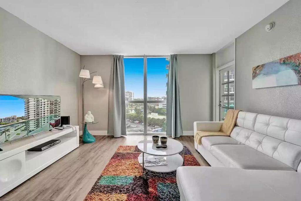a living room with a white couch and a tv at Amazing Apartment on hollywood beach TIDES in Hollywood