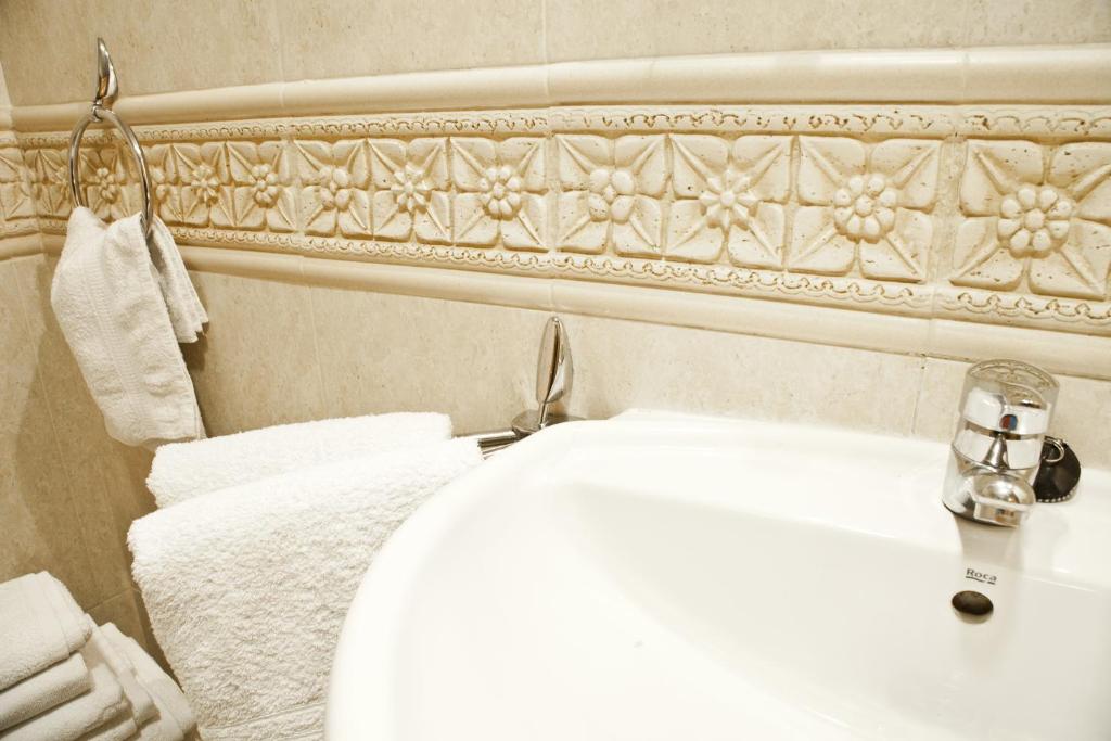 a bathroom with a white toilet and a sink at Apartamentos Carolina in Torremolinos
