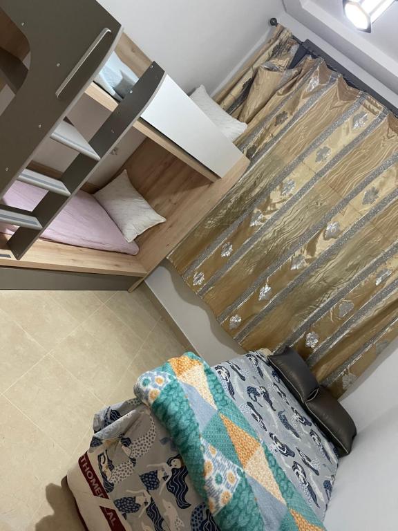 un letto in una stanza con un cassetto con una coperta sul pavimento di Appart Swim & Beach a Sidi Bouzid