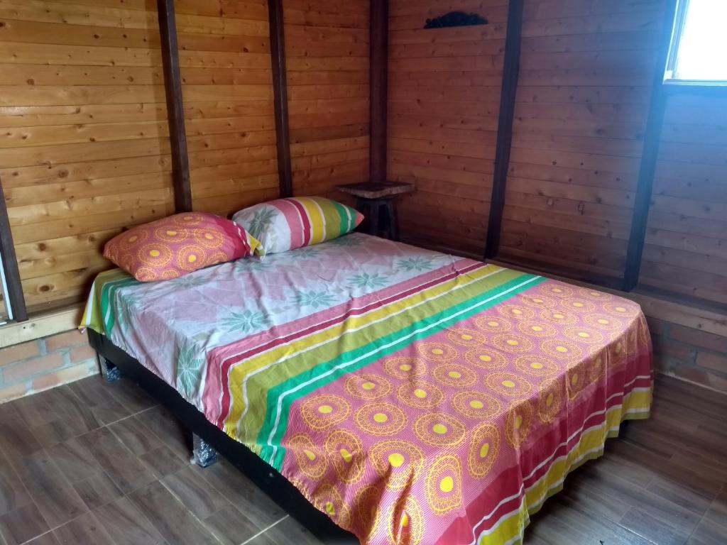 a bed with two pillows sitting in a room at Casa de Barro Ecodomo in Los Santos