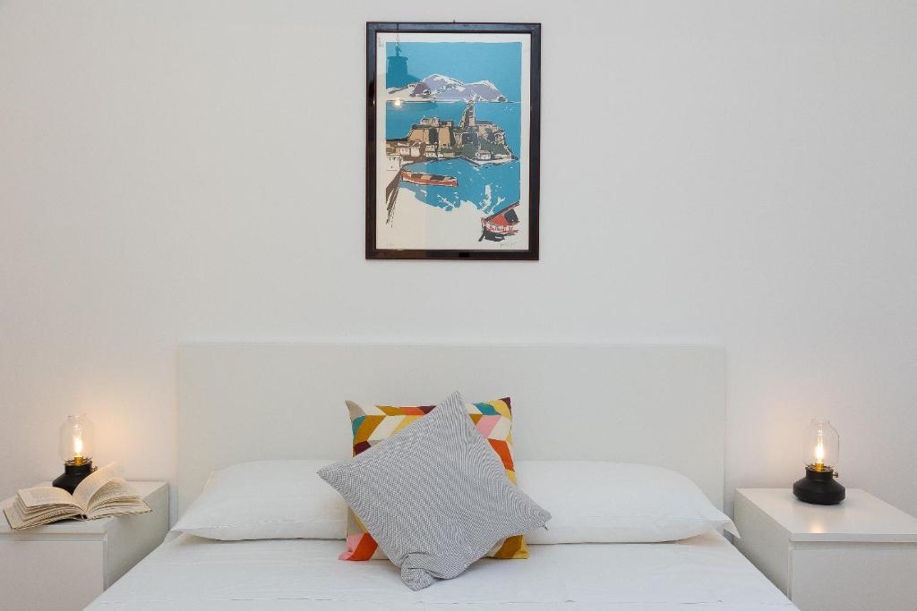 Augusto Imperatore by Rental in Rome في روما: غرفة نوم بسرير ابيض مع مواقف ليلتين