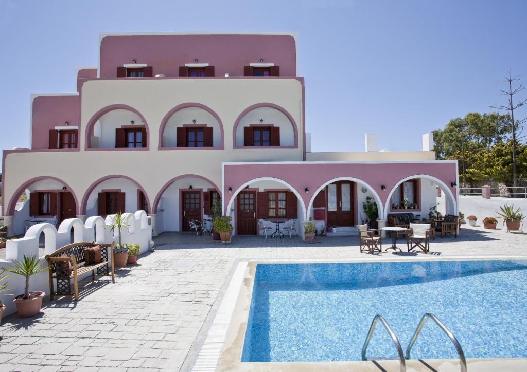uma villa com piscina em frente a um edifício em Villa Koronios em Fira