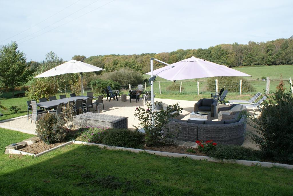 eine Terrasse mit Tischen, Stühlen und Sonnenschirmen in der Unterkunft Chambres & Table d'hôtes de La Vieille Ferme in Salon-la-Tour