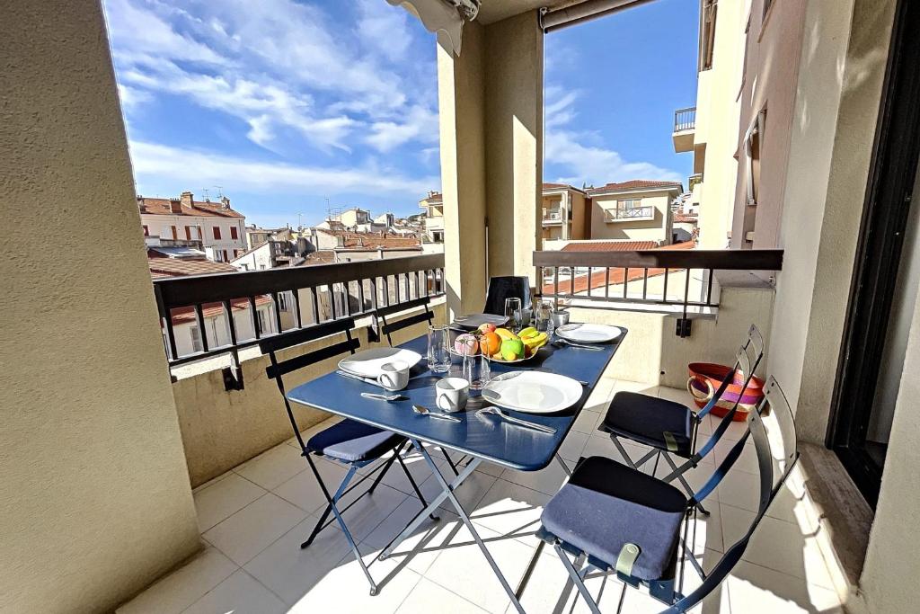 einen Balkon mit einem blauen Tisch und Stühlen in der Unterkunft Stunning 1 BR 3 pers Résidence Cannes Suquet Vieux Port Croisette 1 mn by Olam Properties in Cannes