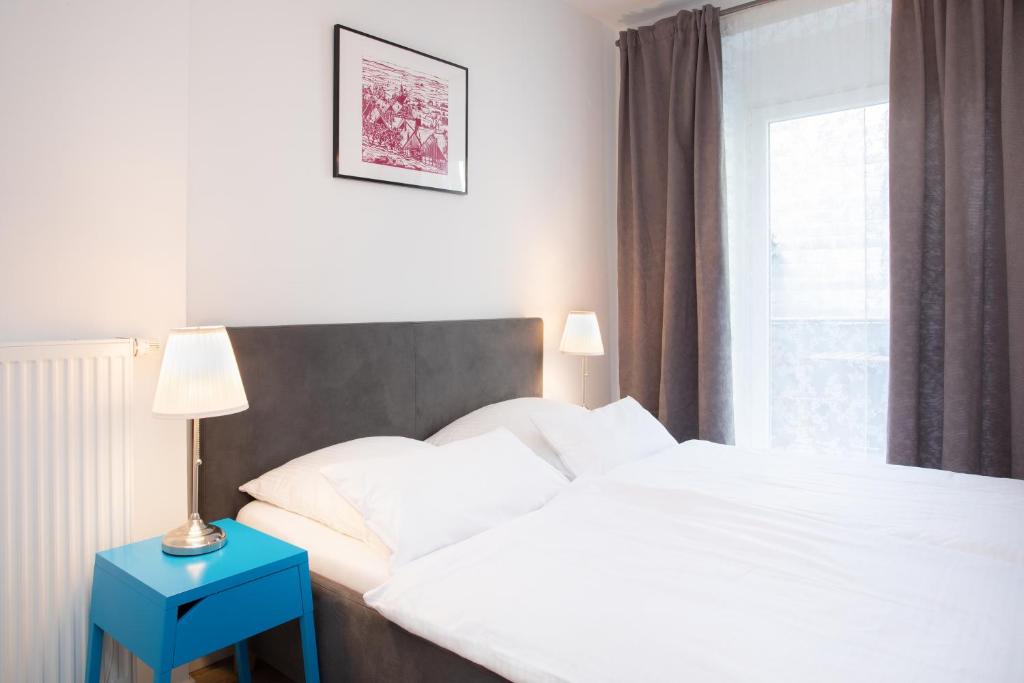 a bedroom with a bed with a blue nightstand and a window at Wertschätzer II - Unter der Wehme in Detmold