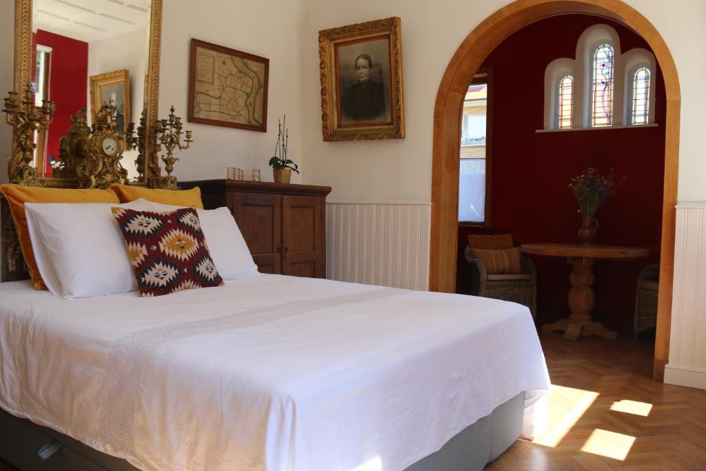 a bedroom with a large white bed in a room at Authentieke privé-kamer bij Karen in Beveren