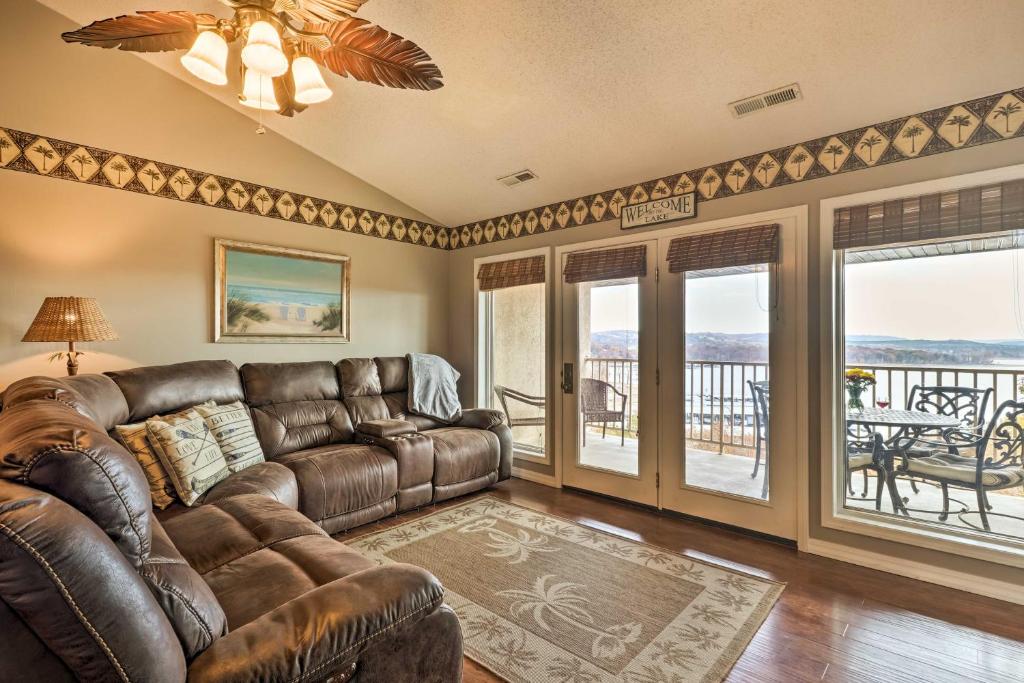 a living room with a leather couch and a balcony at Lakefront Branson Condo, Near Silver Dollar City! in Branson
