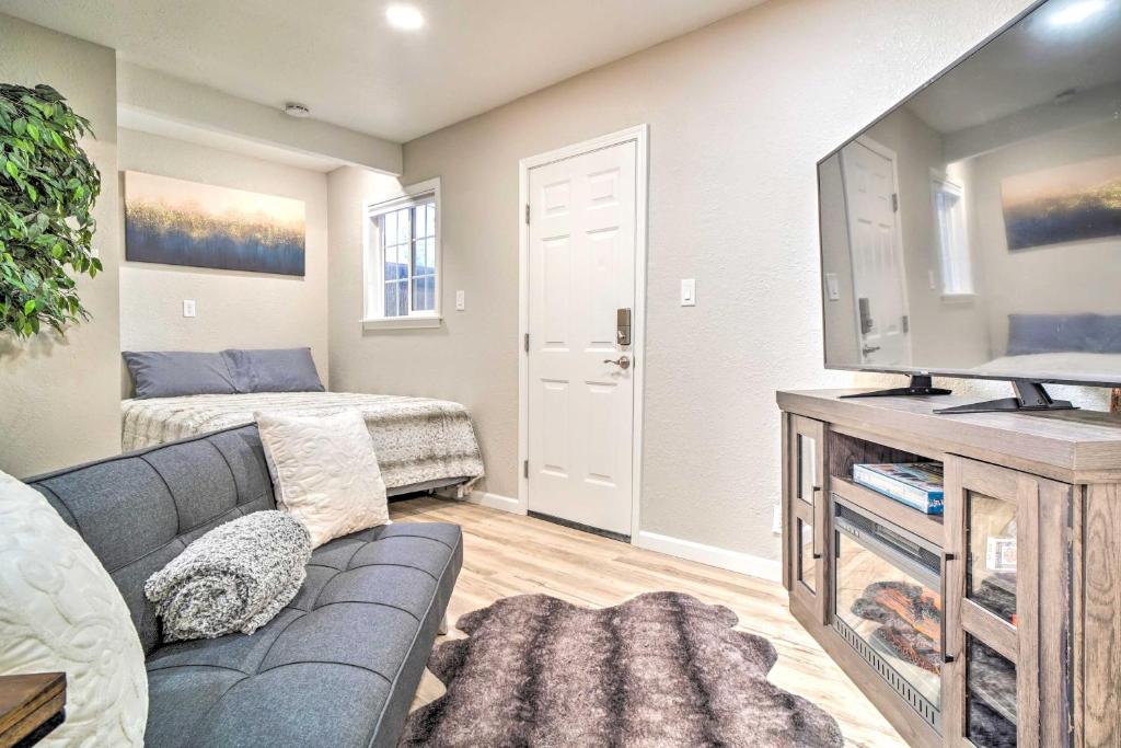 a living room with a couch and a tv at Adorable Studio Cottage Walkable to Town! in Grants Pass