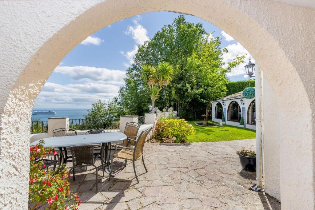 an archway over a patio with a table and chairs at Seahaven in Torquay