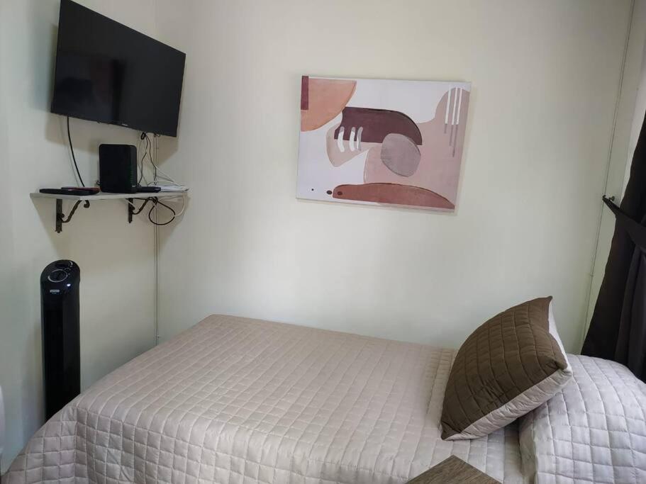 1 dormitorio con 1 cama y una foto en la pared en Acogedor aparta estudio en Medellín, en Medellín
