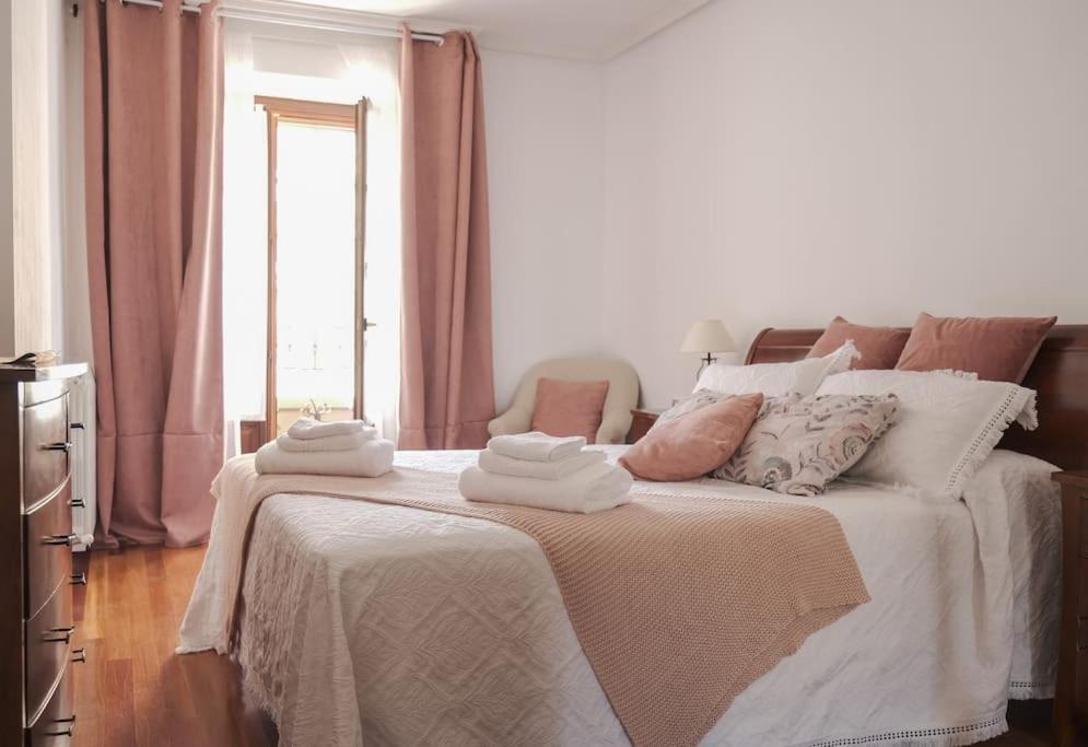 a bedroom with a large bed with towels on it at La casina de cori in Luarca