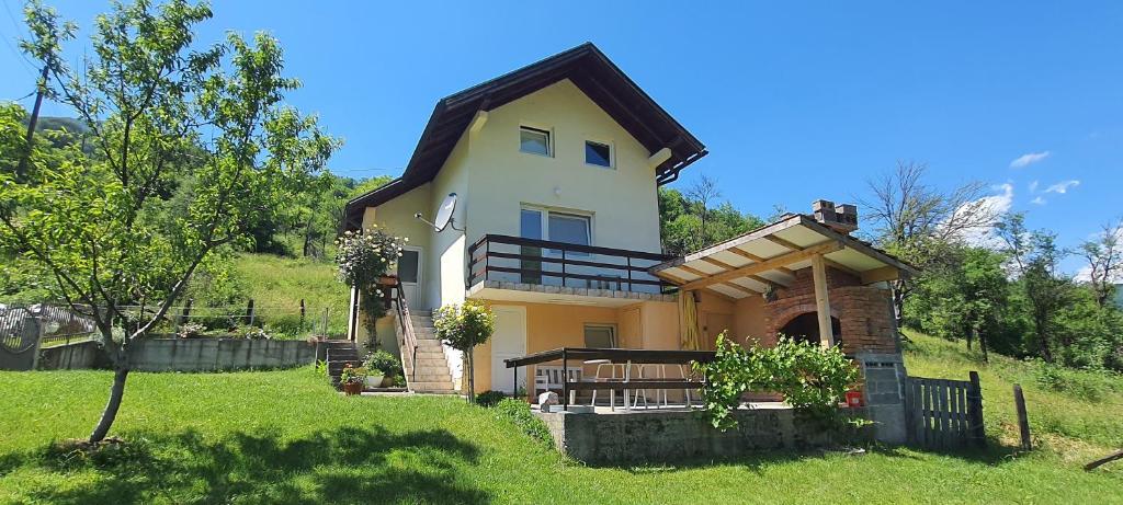 una casa gialla con balcone su una collina di Vikendica Jovanovic a Foča