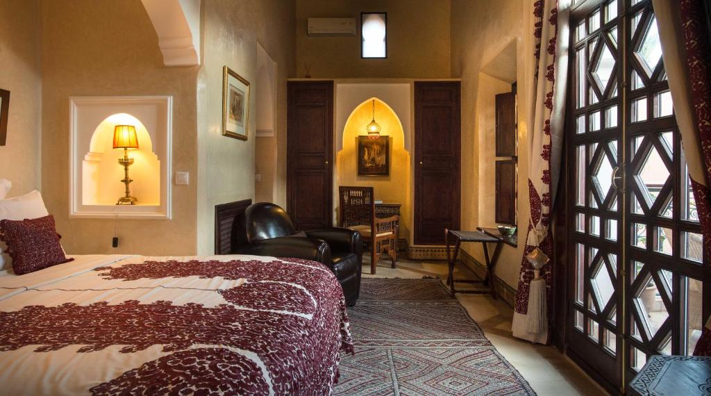 ein Schlafzimmer mit einem Bett und einem Stuhl in einem Zimmer in der Unterkunft Palais Riad Lamrani in Marrakesch
